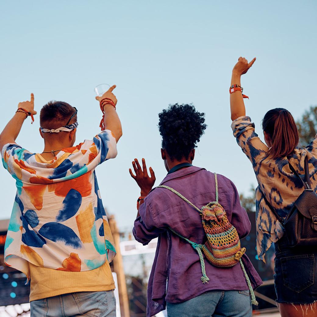 Friends raising hands at an outdoor festival