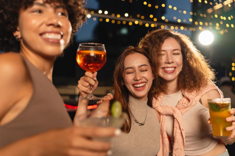 Friends smiling with drinks at a celebration